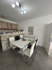 a kitchen and dining room with a white table and chairs at Apartment Petar in Kotor