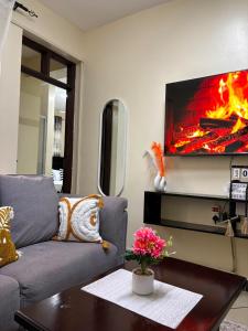 a living room with a couch and a tv on a wall at Terry's 2br sunsweet resort shanzu,mombasa in Mombasa +10 photos