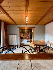 a room with a wooden ceiling with a table and chairs at Appartement L'argentiere la bessée in LʼArgentière-la-Bessée