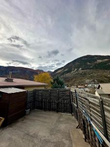 a balcony of a house with a fence and mountains at Appartement L'argentiere la bessée in LʼArgentière-la-Bessée