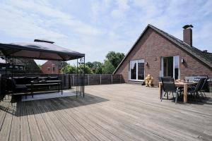 a deck with a table and chairs and an umbrella at Ferienwohnung 12 Monkeys in Stuhr
