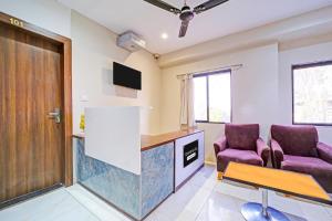a waiting room with two purple chairs and a table at Super Townhouse LIG Main Road Indore in Indore