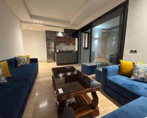 a living room with blue couches and a coffee table at Appartement Sidi Rahal Oceanic in Sidi Rahal