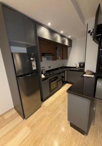a kitchen with a stainless steel refrigerator and a counter at Appartement Sidi Rahal Oceanic in Sidi Rahal
