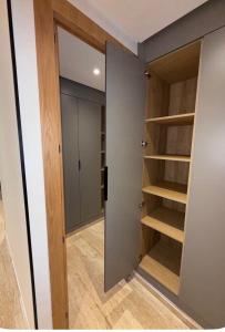 a walk in closet with wooden shelves and a door at Appartement Sidi Rahal Oceanic in Sidi Rahal +19 photos