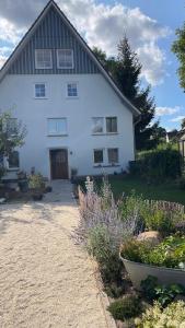 a large white house with a yard with flowers at Zimmer Mühlenbach, ein Zimmer in FeWo mit 2 Zi in Schieder-Schwalenberg