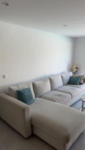a white couch in a living room with blue pillows at Azure Pool Villa in Marseille