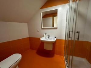 a bathroom with a toilet and a sink and a shower at Las Catedrales in Foz +22 photos