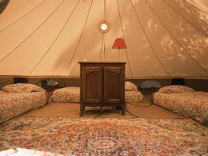 a room with two beds and a table in a tent at Auberge Aparra Surfcamp Ondres in Ondres