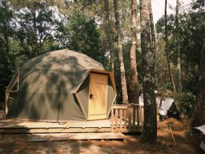a dome tent sitting on a deck in the woods at Auberge Aparra Surfcamp Ondres in Ondres
