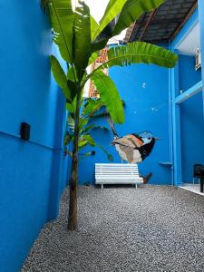 a mural of a bird sitting on a bench next to a tree at Pousada Ocean Mare in Praia do Frances