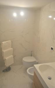 Baño blanco con aseo y lavamanos en Smart Central Apartments San Gregorio, en Nápoles