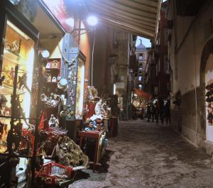 an alley with a lot of shops in a city at Smart Central Apartments San Gregorio in Naples