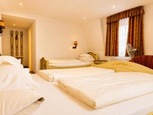 a bedroom with three beds in a room at Hotel Tilman Riemenschneider by ANS in Rothenburg ob der Tauber