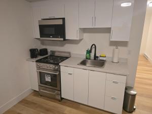 a kitchen with a stove and a sink and a microwave at TeeBams's Comfy Home in Riverview