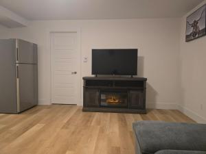 a living room with a fireplace with a flat screen tv at TeeBams's Comfy Home in Riverview