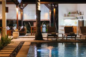 a resort with a swimming pool and a living room at Dolce Magia in Gili Trawangan