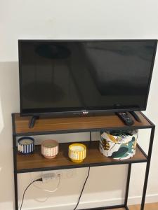 a flat screen tv sitting on a tv stand at L appart in Joué-lès-Tours