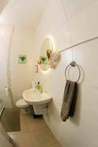 a white bathroom with a sink and a mirror at Hostel Casinha Tropical in Rio de Janeiro +109 photos