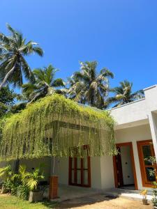 a building with palm trees in the background at Ruchi Villa in Wadduwa