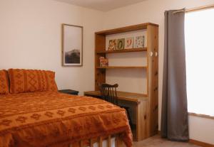 a bedroom with a bed and a book shelf at El Ranchito Alegre Private 3BR Home in Historic Corrales in Corrales