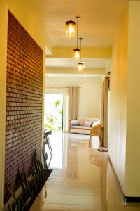 a hallway with a brick wall and a couch at Ruchi Villa in Wadduwa +27 photos