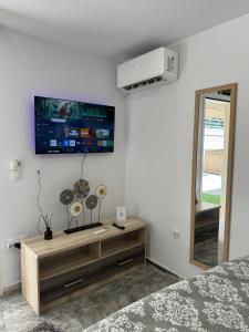 a bedroom with a tv on the wall and a bed at Modern studio in Athens