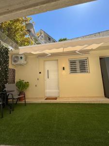 a backyard with green grass and a white door at Modern studio in Athens