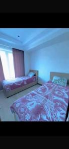 a bedroom with two beds and a blue light at Novel in Korumdy