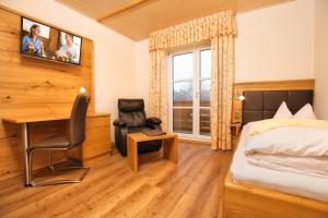 a bedroom with a bed and a desk and a chair at Der Glaserhof - WaldZeitHotel in Lam