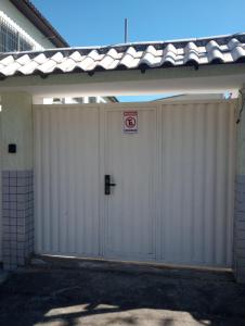 a white garage door with a no parking sign on it at Casa no centro - perto de tudo in Itaguaí