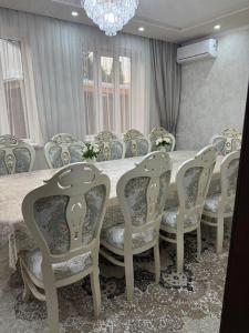 a dining room with a table with chairs and a chandelier at Family Villa in Osh