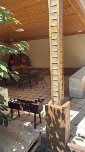 a patio with a table and benches under a roof at Family Villa in Osh