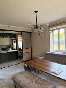 a living room with a table and a kitchen at Family Villa in Osh
