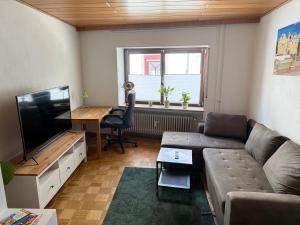 a living room with a couch and a flat screen tv at Ferienwohnung Stiegel in Ingelheim am Rhein