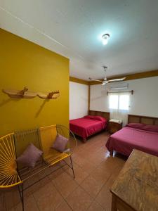 a room with two beds and a yellow wall at Casa Santa Elena in Brisas de Zicatela +12 photos