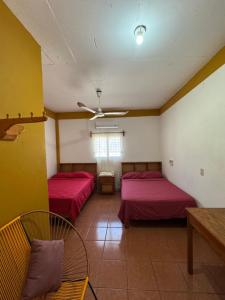 a room with two beds and a table and chairs at Casa Santa Elena in Brisas de Zicatela