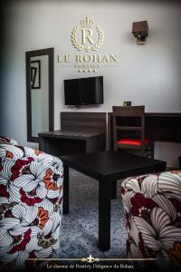 a living room with a table and two chairs at Hôtel Le Rohan Charme et Caractère in Pontivy
