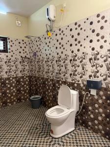 a bathroom with a white toilet in a room at Mud apples stay in Varkala