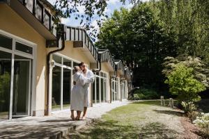 a bride and groom kissing in front of a building at Der Glaserhof - WaldZeitHotel in Lam