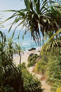 a beach with people on the sand and the ocean at Mud apples stay in Varkala