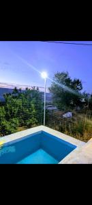 a blue swimming pool with a light on top of it at La Cigarra in Ronda