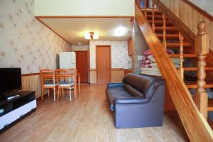 a living room with a couch and a table and a staircase at Pyeongchang Hyundai Sweet Village in Pyeongchang