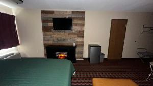 a room with a fireplace with a television and a fire place at Chesaning INN & Suites in Chesaning