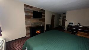a hotel room with a bed and a fireplace at Chesaning INN & Suites in Chesaning
