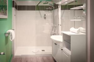 a white bathroom with a shower and a sink at Hôtel Le Rohan Charme et Caractère in Pontivy +52 photos