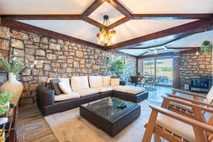 a living room with a couch and a stone wall at Luna Pool Apartment in Danilovgrad