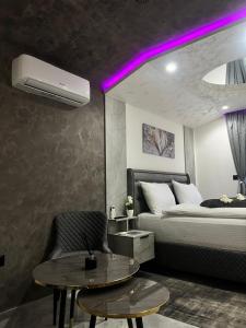 a bedroom with a bed and a table and purple lights at Ambasada Rooms in Sarajevo