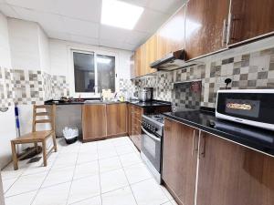 a kitchen with stainless steel appliances and wooden cabinets at Rose Building in Dubai