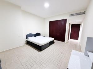 a bedroom with a bed in a white room at Rose Building in Dubai